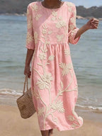 Woman wearing a light pink floral round neck midi dress - lifestyle photo