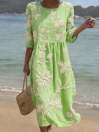 Woman wearing a mint green floral round neck midi dress - lifestyle photo