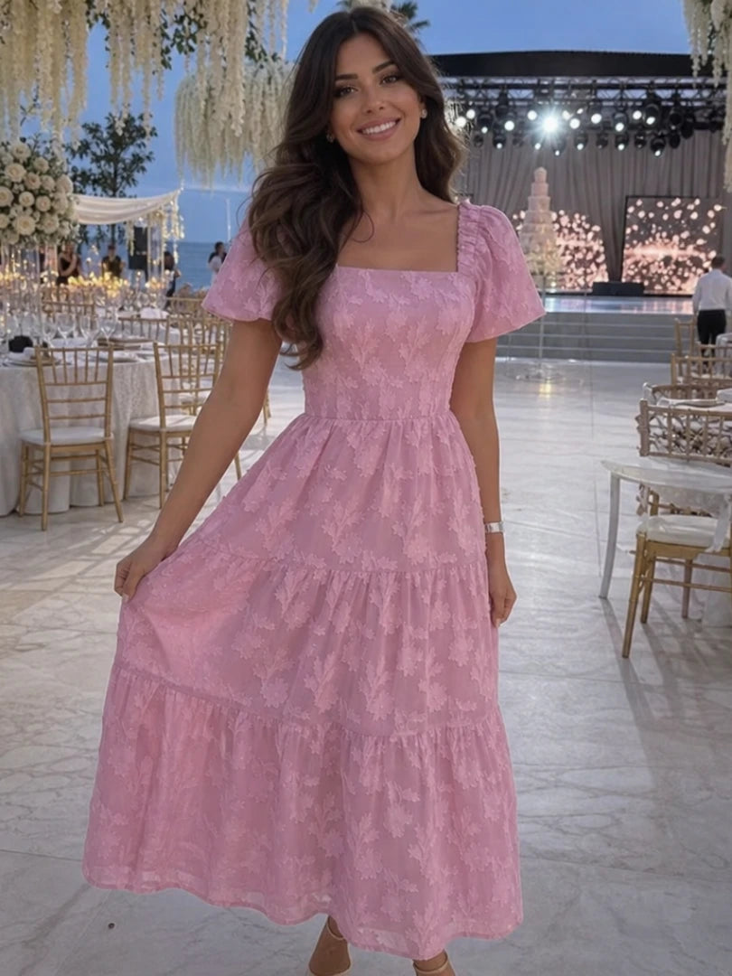 Woman wearing a pink floral textured short sleeve midi dress - studio photo