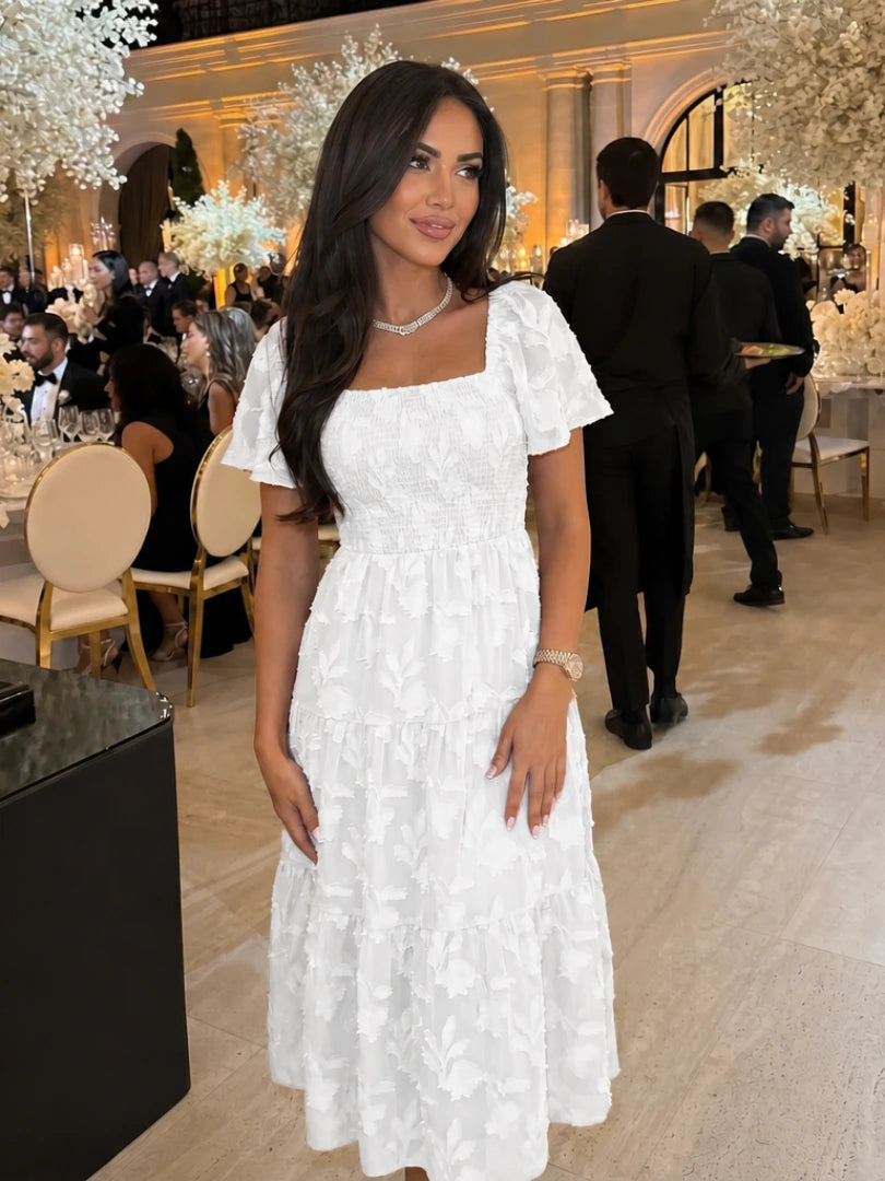 Woman wearing a white floral textured short sleeve midi dress - editorial style photo