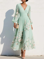 Woman wearing a light green floral v-neck chiffon midi dress - studio photo