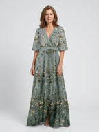 Woman wearing a green floral v-neck elbow-sleeve maxi dress - studio photo
