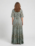 Woman wearing a green floral v-neck elbow-sleeve maxi dress - studio photo