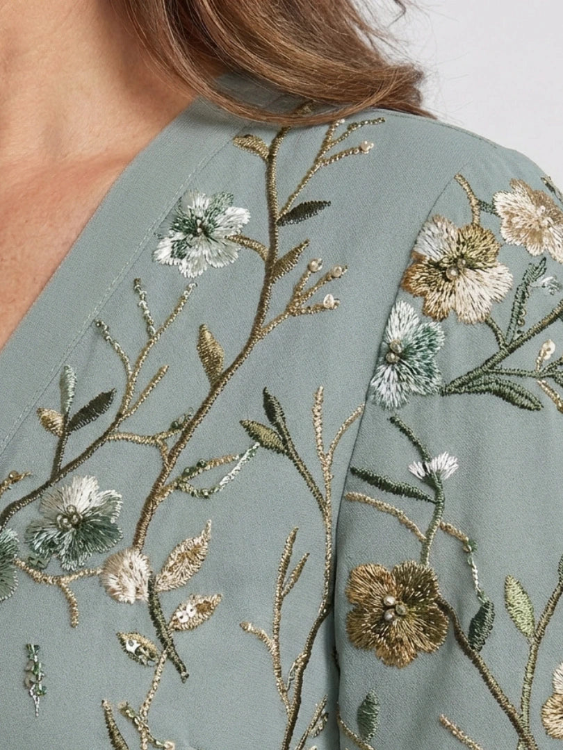 Woman wearing a green floral v-neck elbow-sleeve maxi dress - studio photo