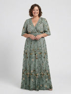 Woman wearing a green floral v-neck elbow-sleeve maxi dress - studio photo