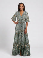 Woman wearing a green floral v-neck elbow-sleeve maxi dress - studio photo