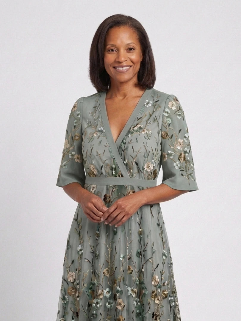 Woman wearing a green floral v-neck elbow-sleeve maxi dress - studio photo