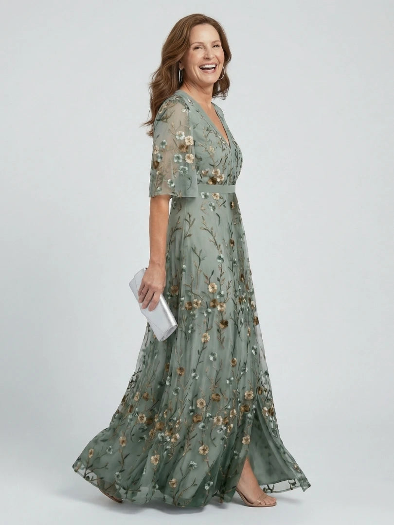 Woman wearing a sage green floral wrap flutter sleeve maxi dress - studio photo