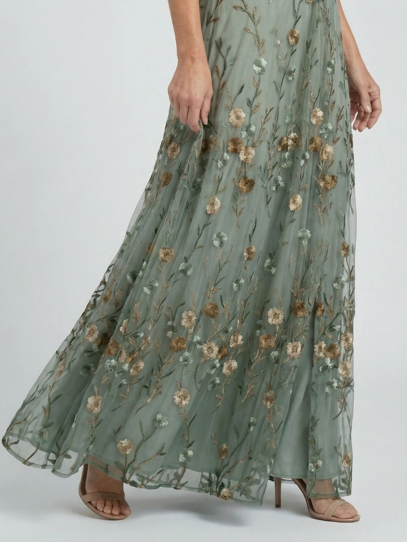 Woman wearing a sage green floral wrap flutter sleeve maxi dress - studio photo