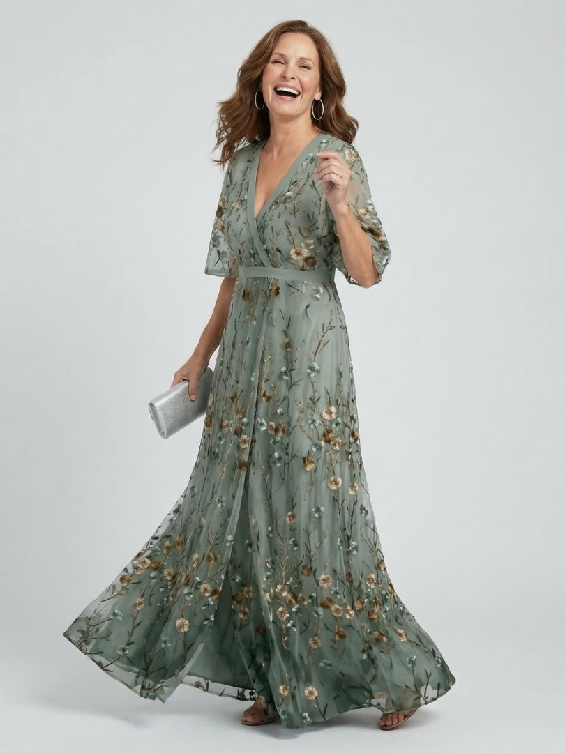 Woman wearing a sage green floral wrap flutter sleeve maxi dress - studio photo