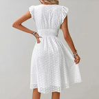 Woman wearing a white flutter sleeve midi dress - outdoor lifestyle photo