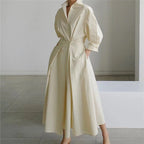 Woman wearing a white front wrap collared maxi dress - studio photo