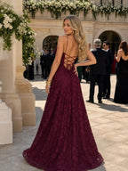 Woman wearing a burgundy full lace spaghetti strap maxi dress - editorial style photo