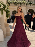 Woman wearing a burgundy full lace spaghetti strap maxi dress - editorial style photo