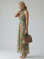 Woman wearing a sage green gathered halter midi dress - studio photo