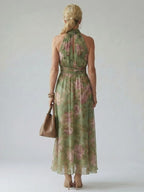 Woman wearing a sage green gathered halter midi dress - studio photo
