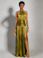Woman wearing a green halter neck pleated high slit maxi dress - studio photo