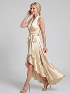 Woman wearing a beige halter wrap asymmetric midi dress - studio photo