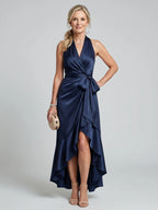 Woman wearing a navy halter wrap asymmetric midi dress - studio photo