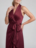 Woman wearing a red halter wrap asymmetric midi dress - studio photo