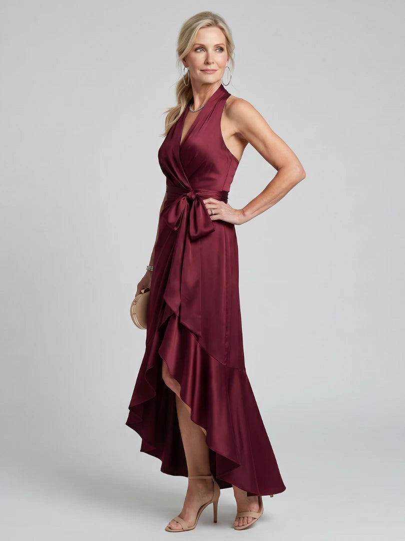 Woman wearing a red halter wrap asymmetric midi dress - studio photo