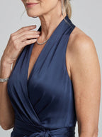Woman wearing a white halter wrap asymmetric midi dress - studio photo