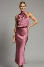 Woman wearing a baked rose high neck draped front dress - studio photo