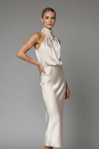 Woman wearing a black floral high neck draped front dress - studio photo