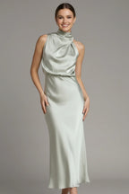 Woman wearing a champagne high neck draped front dress - studio photo