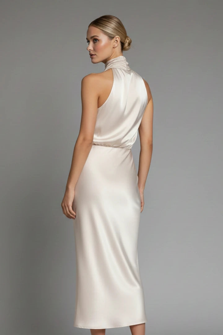 Woman wearing a champagne high neck draped front dress - studio photo