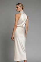 Woman wearing a champagne high neck draped front dress - studio photo