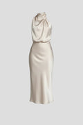 Woman wearing a champagne high neck draped front dress - studio photo