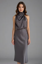 Woman wearing a grey high neck draped front dress - studio photo