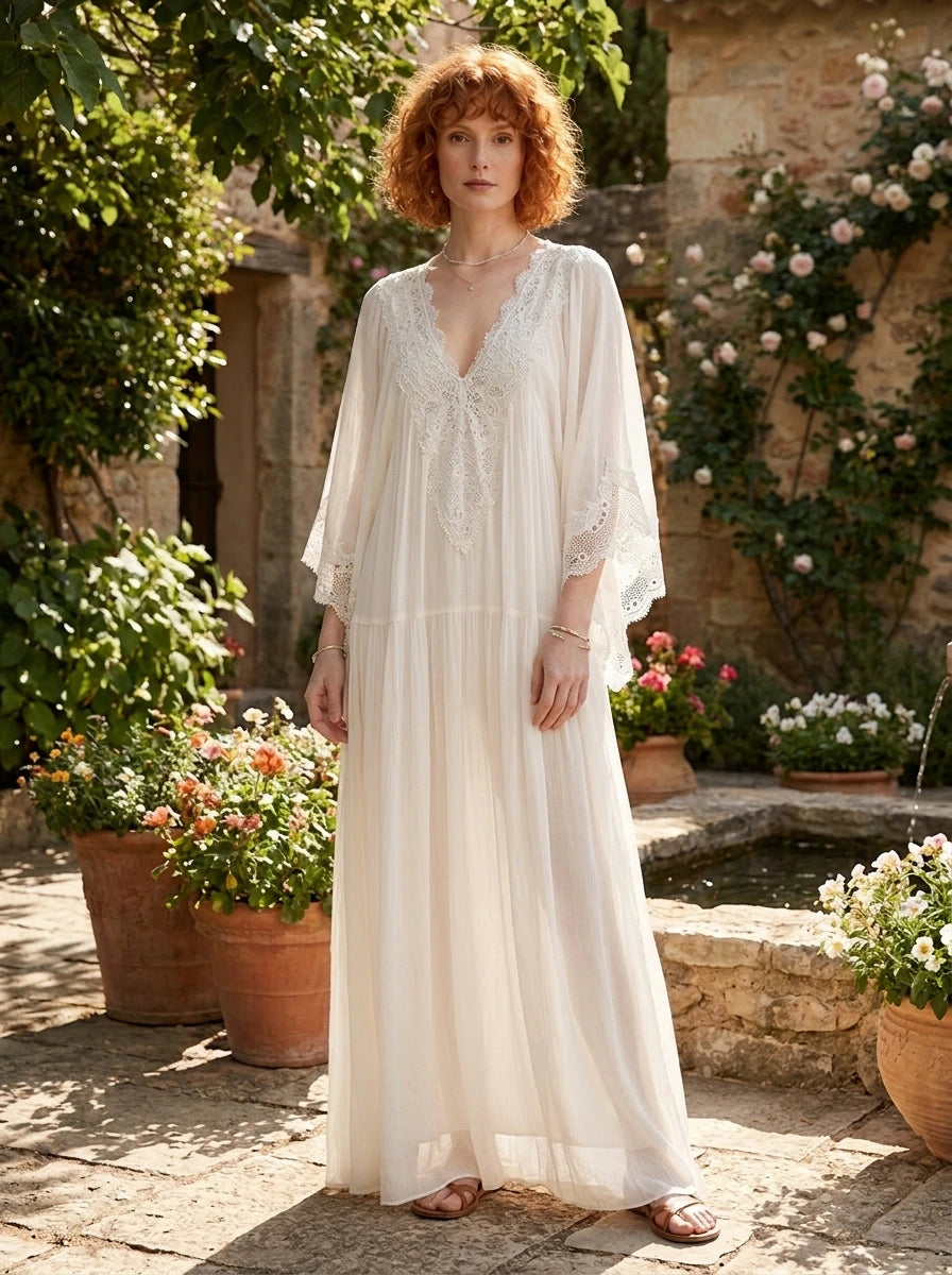 Woman wearing a white lace v-neck batwing sleeve chiffon maxi dress in a garden courtyard