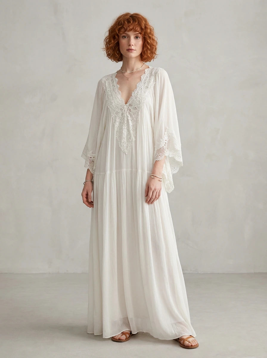 Woman wearing a white lace v-neck batwing sleeve chiffon maxi dress in a studio setting