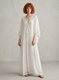 Woman wearing a white lace v-neck batwing sleeve chiffon maxi dress in a studio setting
