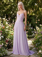 Woman wearing a lavender purple lace bustier maxi dress in a garden