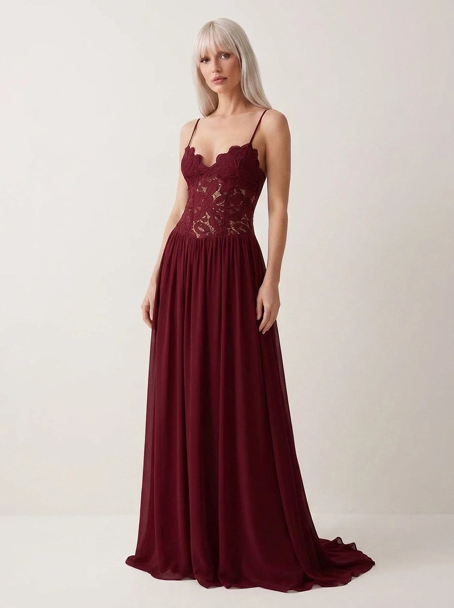 Woman wearing a wine red lace bustier maxi dress in a studio setting