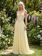 Woman wearing a yellow lace bustier maxi dress in a garden
