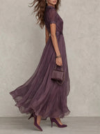 Woman wearing a purple lace trim gathered waist maxi dress - studio photo