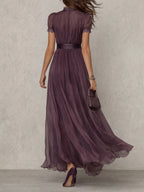 Woman wearing a purple lace trim gathered waist maxi dress - studio photo