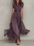 Woman wearing a purple lace trim gathered waist maxi dress - studio photo
