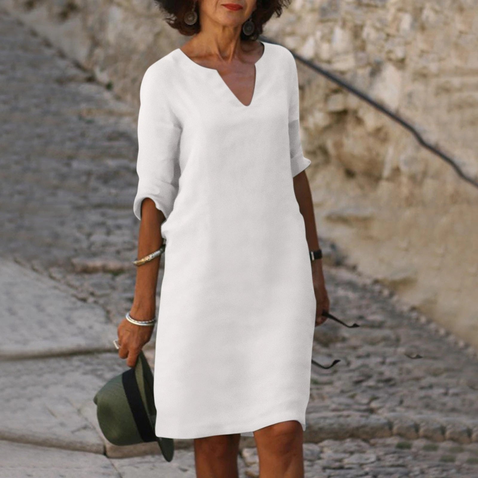 Woman wearing a white lightweight summer everyday dress - editorial style photo