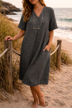 Woman wearing a black linen v-neck relaxed midi dress - lifestyle photo
