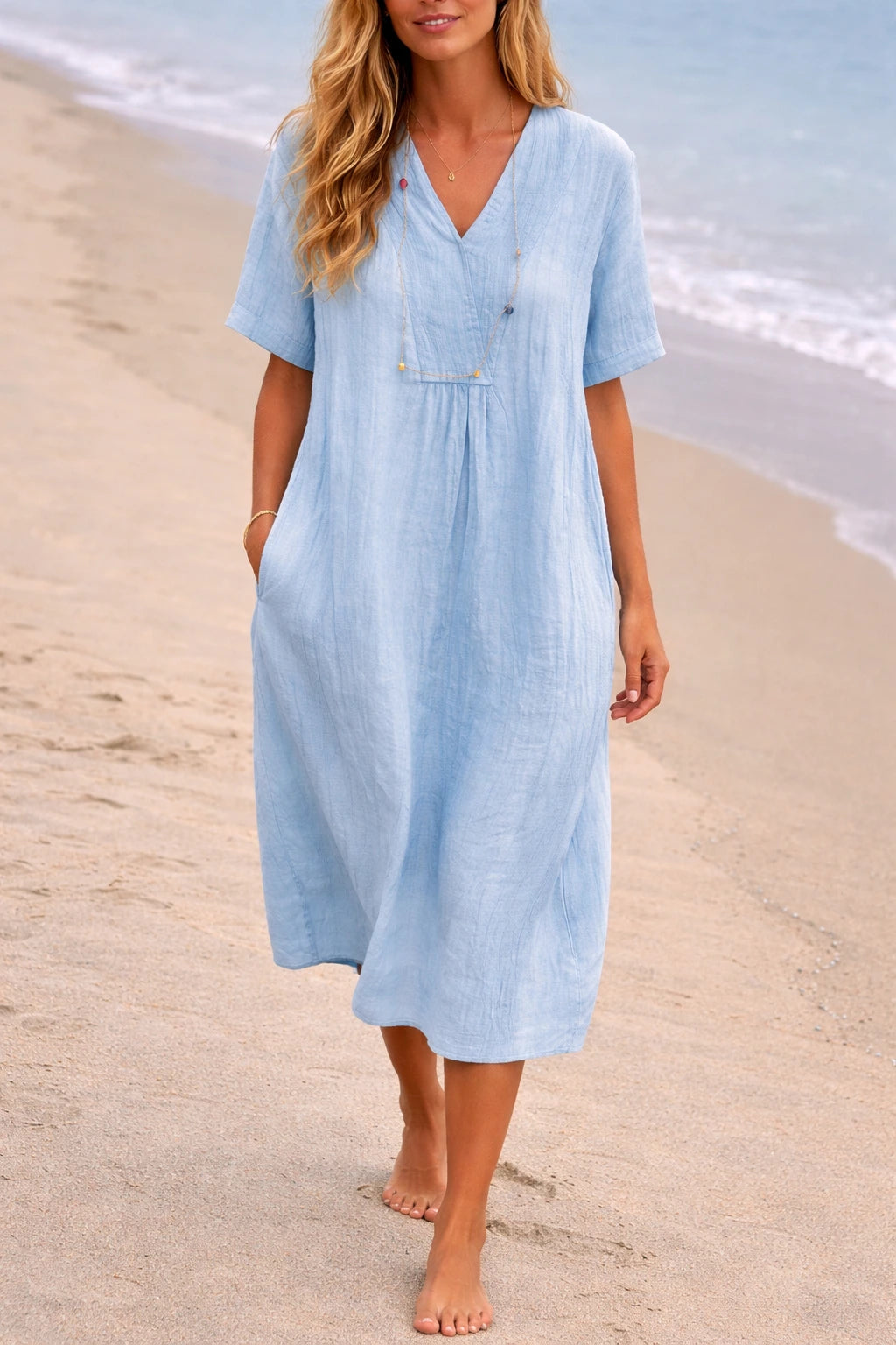 Woman wearing a light blue linen v-neck relaxed midi dress - lifestyle photo