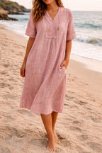 Woman wearing a pink linen v-neck relaxed midi dress - lifestyle photo