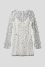 Woman wearing a white mesh overlay sleeveless mini dress - studio photo