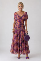 Woman wearing a brown off-shoulder draped midi dress - studio photo