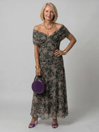 Woman wearing a dark green off-shoulder draped midi dress - editorial style photo