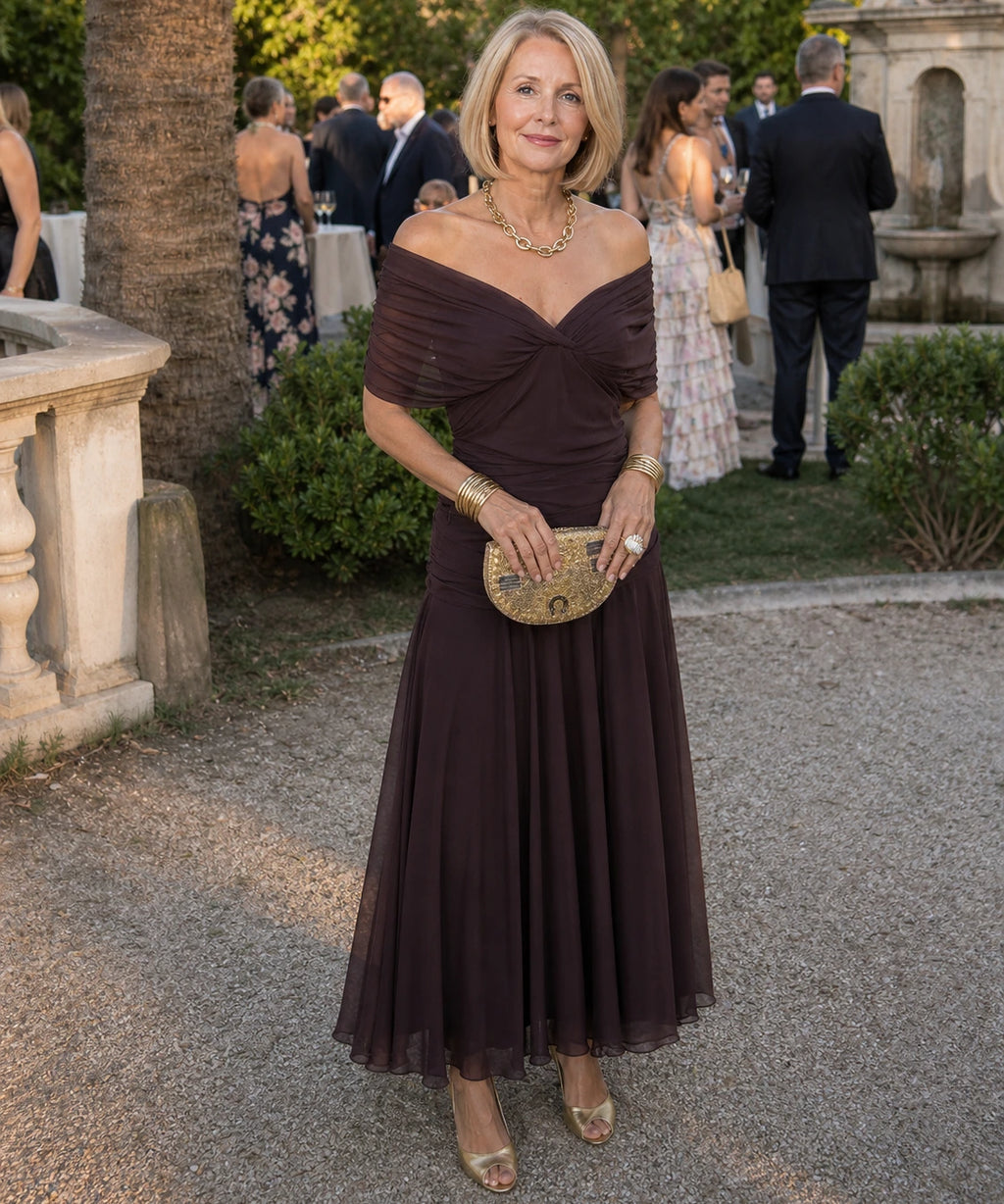 Woman wearing a purple off-shoulder draped midi dress - studio photo